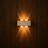 Stein travertine LED wall light glowing on a wood wall, NOGAN Lights