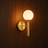 Dögg modern gold-coloured designer wall light on a wall, NOGAN Lights
