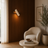 Travertine and wood wall light casting a warm glow in a bright Nordic interior