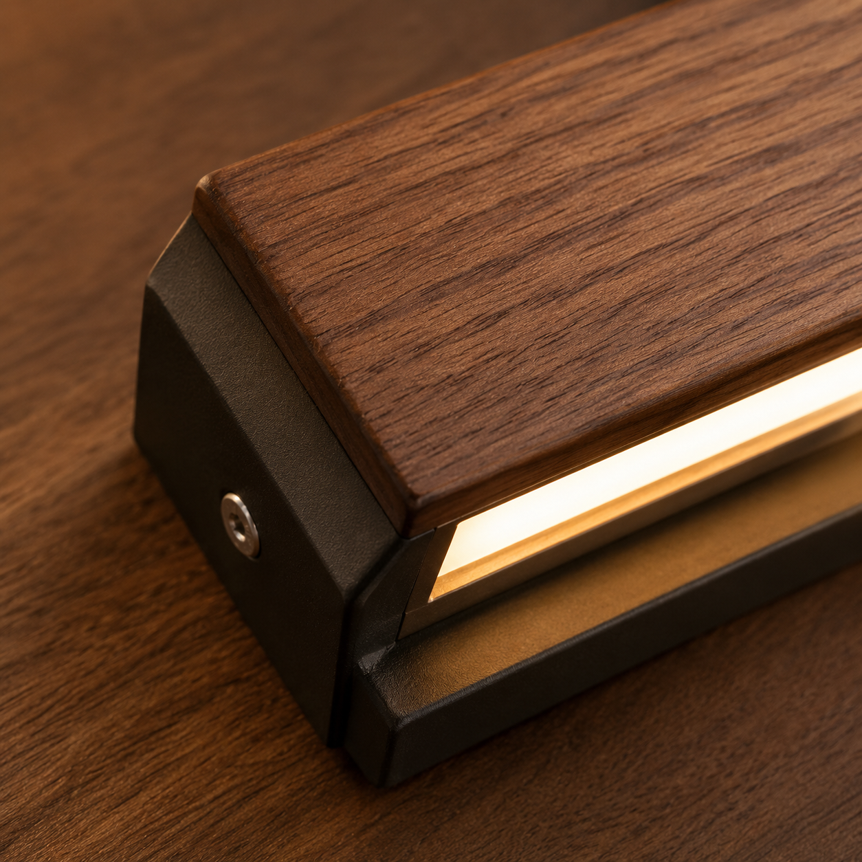 Close-up of rich walnut wood grain on the Alm wall light